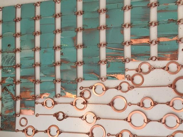 Tejido de láminas de cobre, compuesta de cuadrados en cobre oxidado, unidos a eslabones circulares de cobre pulido. 