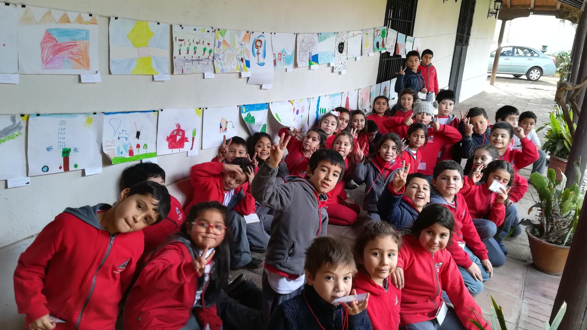 Grupo de estudiantes junto a sus obras de arte en exhibición