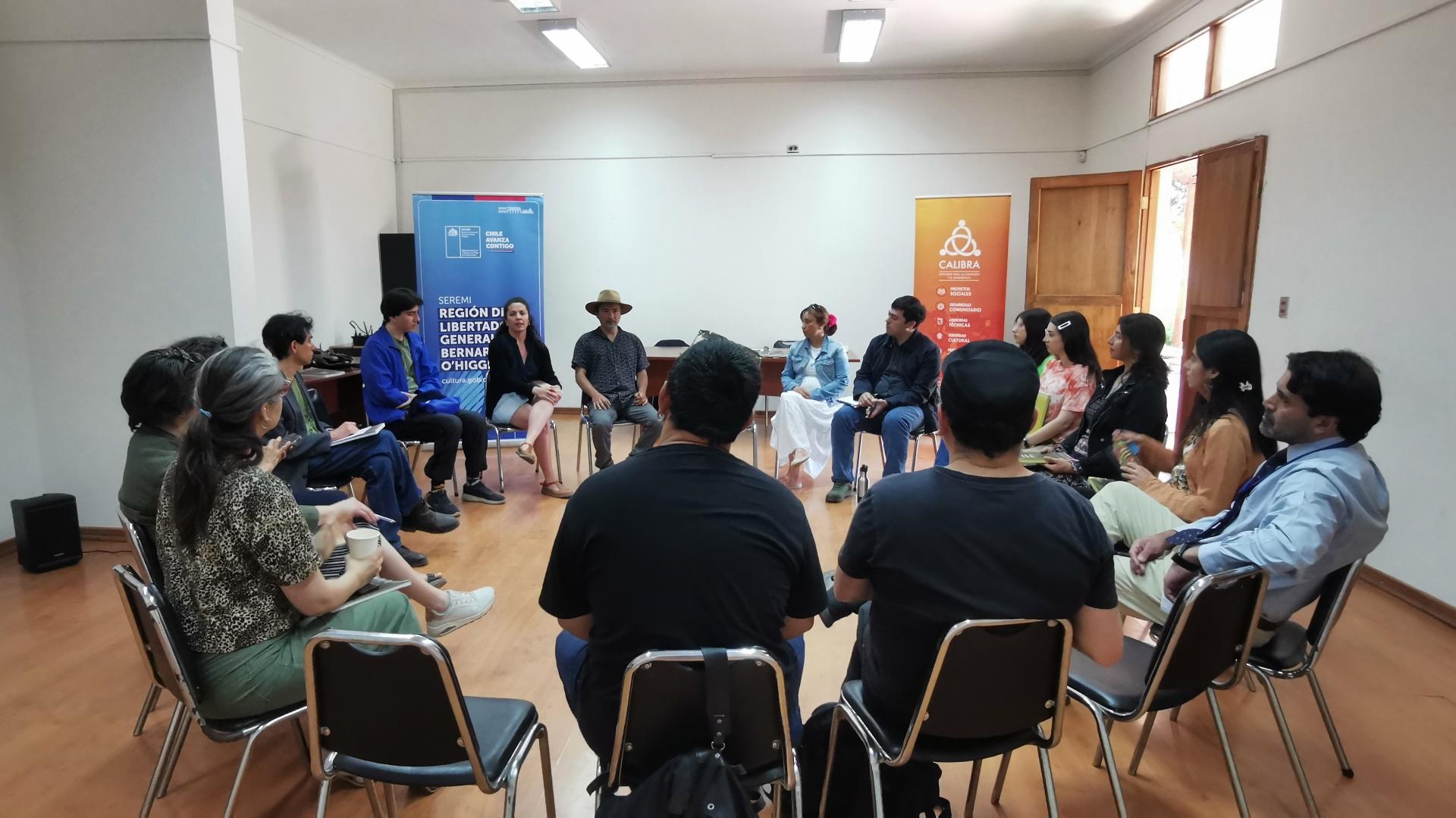 Participantes del taller "Para enseñar el Canto a lo Poeta" personas sentadas en circulo en un salon