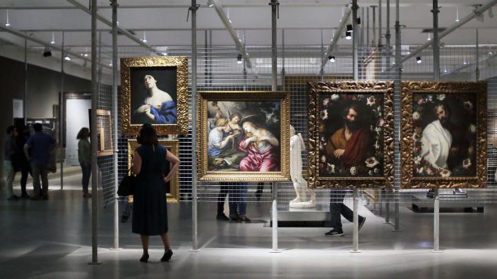 Gente mirando cuadros en una sala de museo