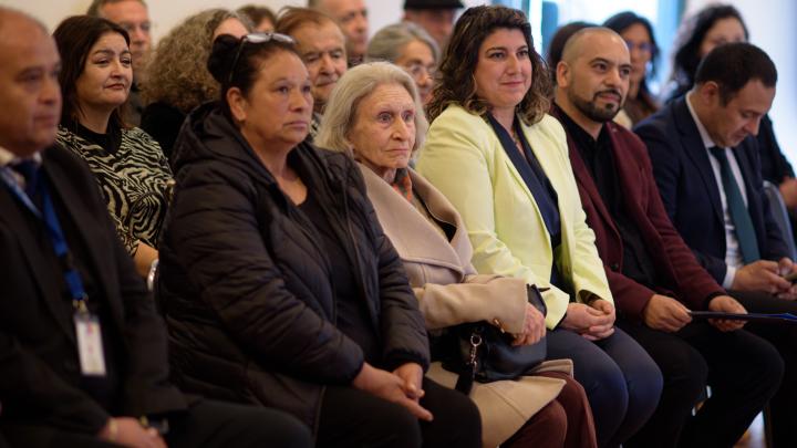 personas sentadas en auditorio escuchando