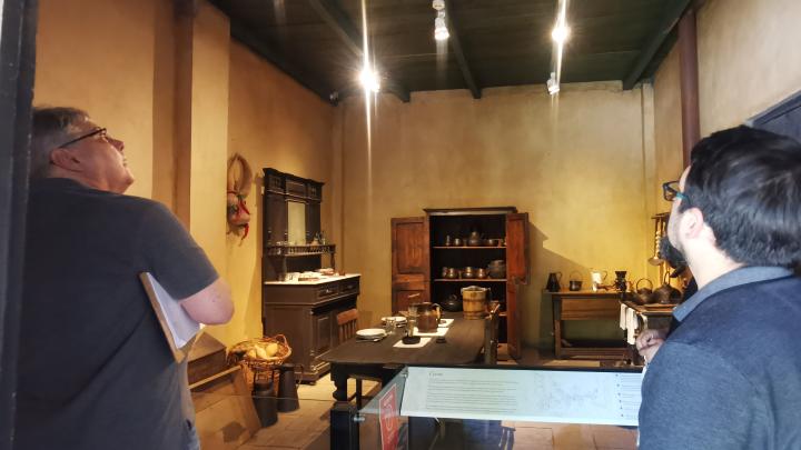 Dos personas observando el interior de una habitación iluminada en dependencias del Museo Regional de Rancagua