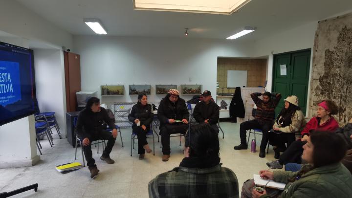 Personas sentadas en un salón observan y dialogan