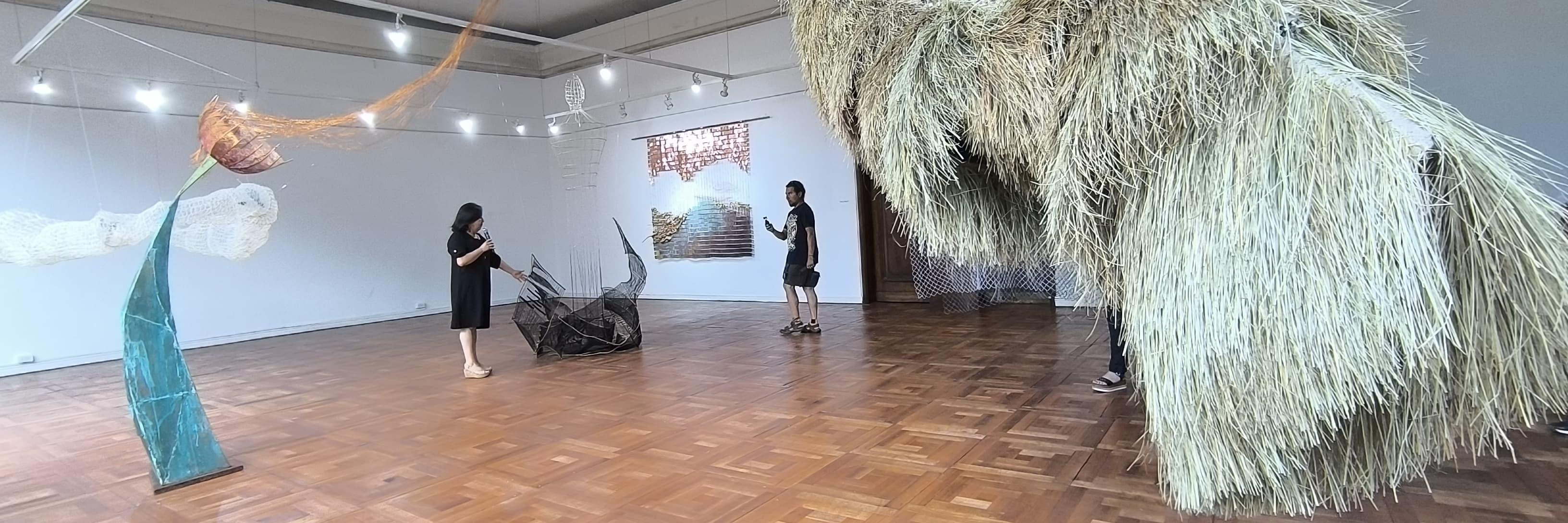 salon con piso de madera con objetos de gran volumen colgando desde el techo