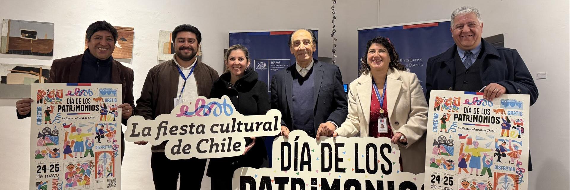 dos mujeres y cuatro hombres sonriuen para la fotografia mientras sostienen letreros que dicen dia de los patrimonios y la fiesta cultural de Chile