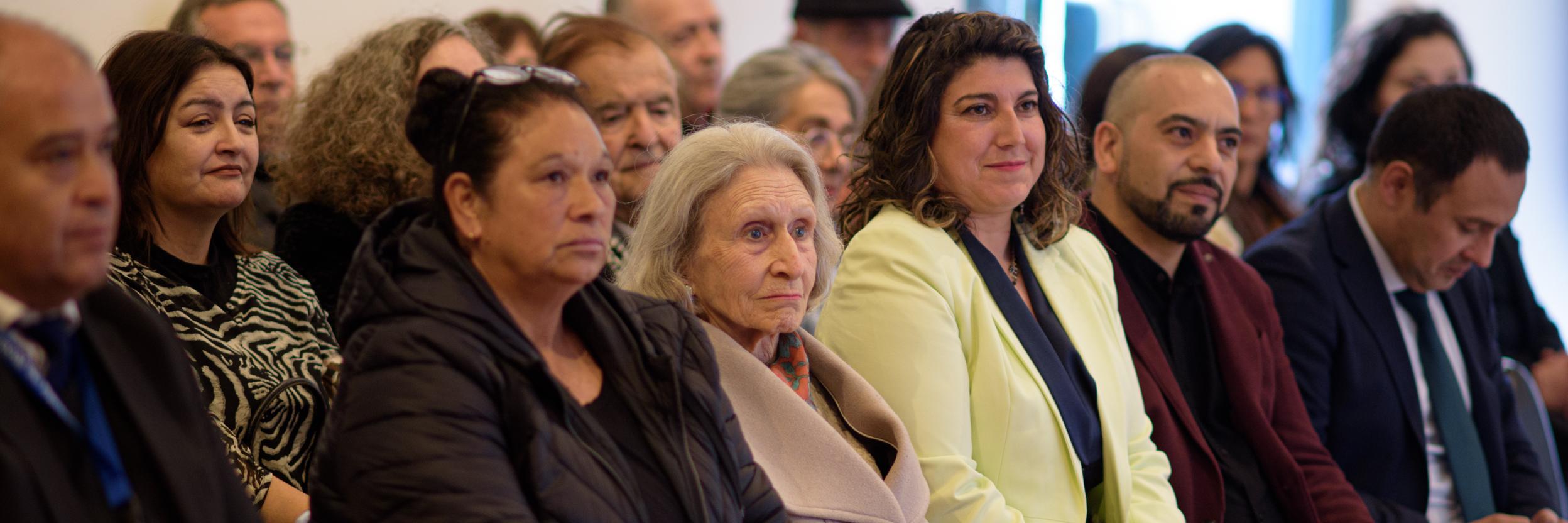 personas sentadas en auditorio escuchando