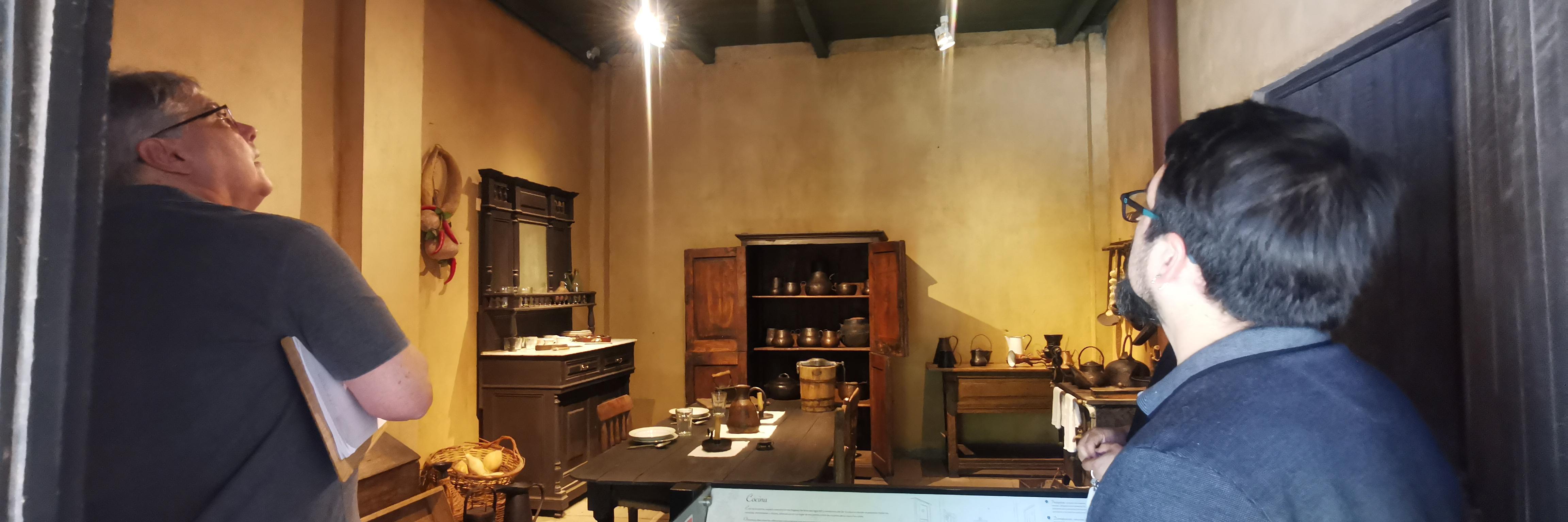 Dos personas observando el interior de una habitación iluminada en dependencias del Museo Regional de Rancagua