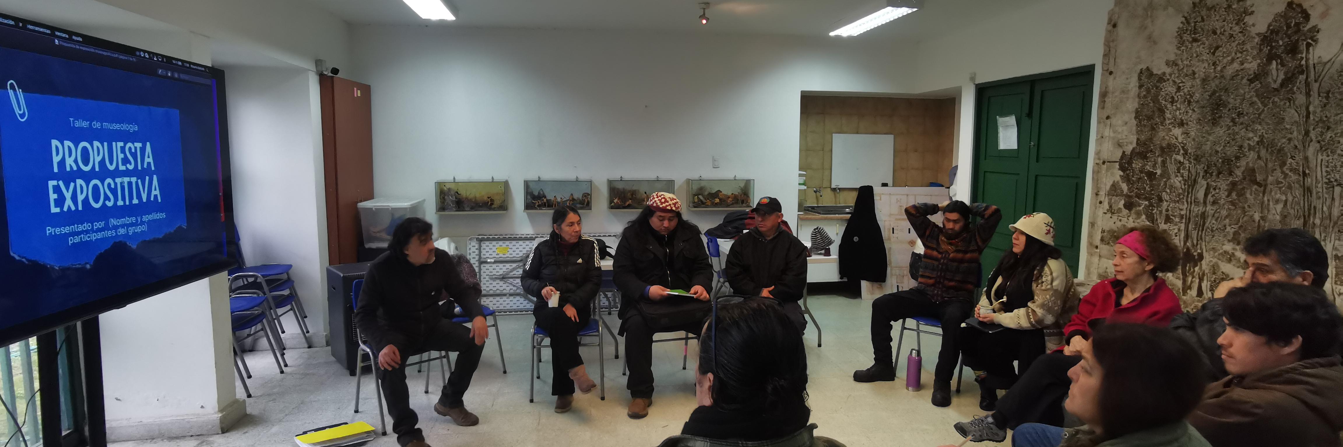 Personas sentadas en un salón observan y dialogan