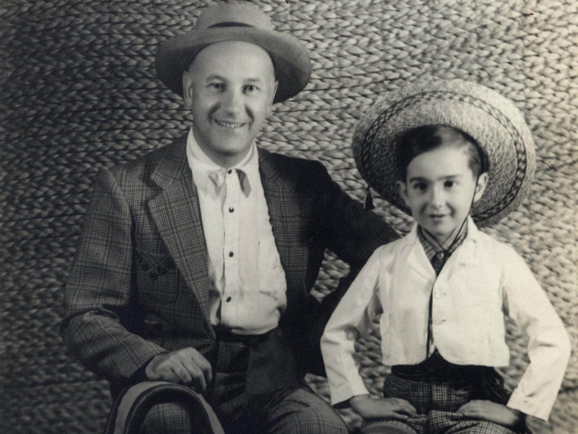 Fotografía en blanco y negro en que aparece padre e hijo vestidos con traje de huaso.