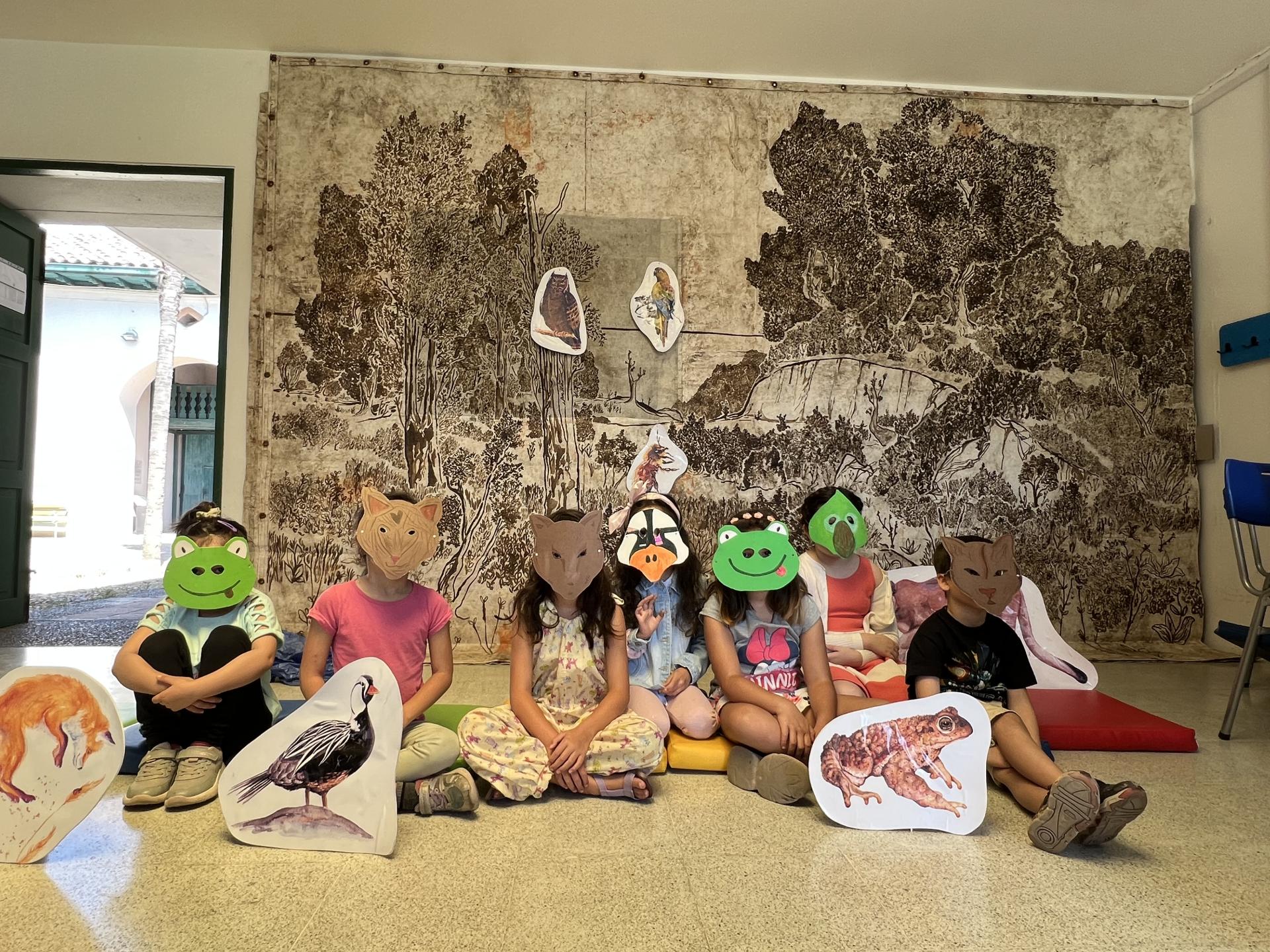 Se aprecia un grupo de niños y niñas utilizando una máscara que representa un animal de la región de O’Higgins.