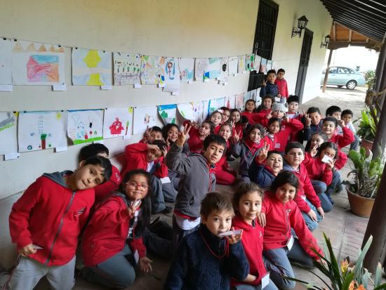 Grupo de estudiantes junto a sus obras de arte en exhibición