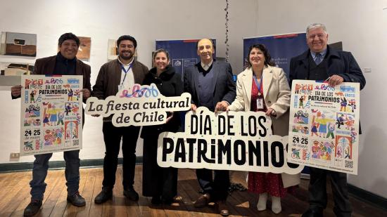 dos mujeres y cuatro hombres sonriuen para la fotografia mientras sostienen letreros que dicen dia de los patrimonios y la fiesta cultural de Chile