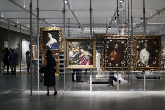 Gente mirando cuadros en una sala de museo