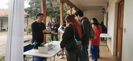 un joven muestra a grupo de adolescentes como fucniona un telescopio virtual