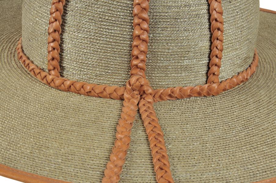 Detalle de bonete, sombrero de hombre en paja teatina trenzada y teñida con tintes naturales, con adornos de cuero trenzado