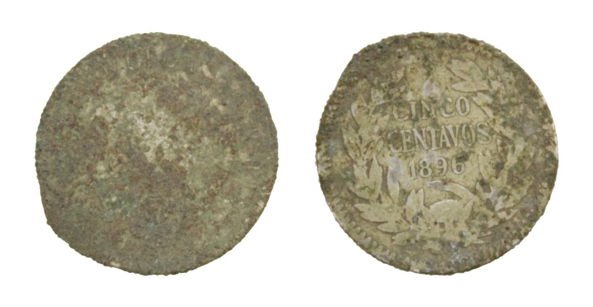 Pieza completa, de forma circular y de color plateado, cubierta en parte por una pátina de color gris oscuro