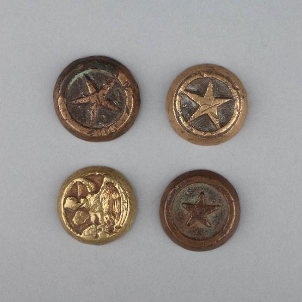Imagen de fondo gris, compuesta por cuatro figuras circulares que corresponden a tejos de metal, cada uno de ellos tiene acuñado un dibujo, los dos primeros una estrella, el tercero un cóndor y el último una estrella.
